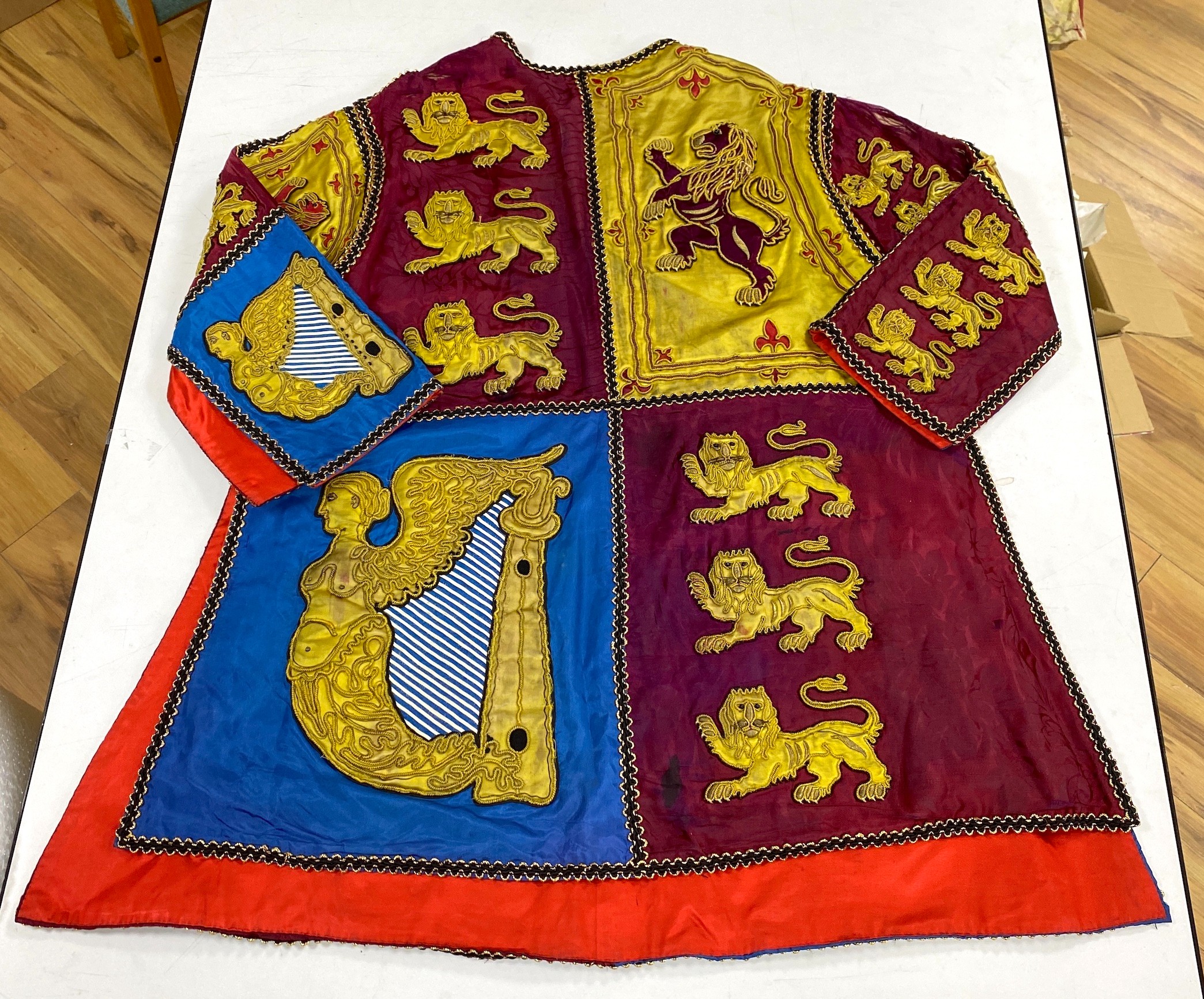 Two QEII Officer's of Arms of The Herald's College embroidered tabards and a similar silk garter, possibly worn for the Coronation of the Queen in 1953